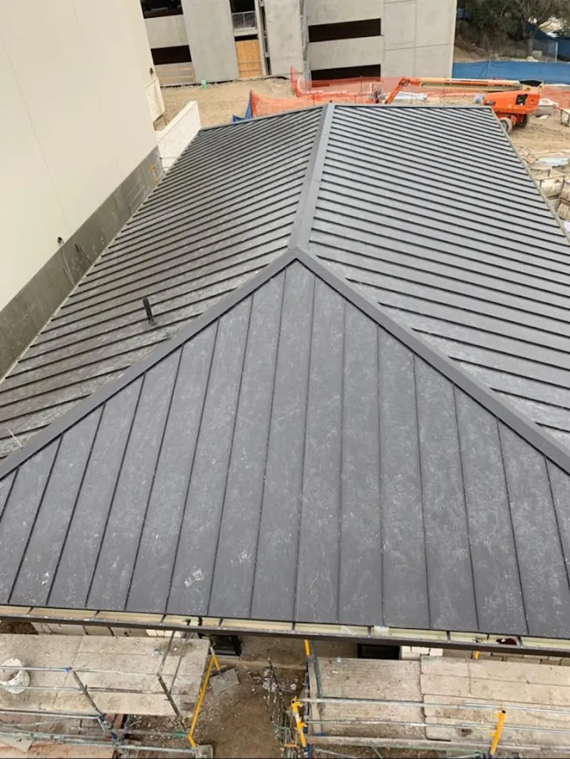 Commercial metal roof construction with crane equipment in Coolbaugh